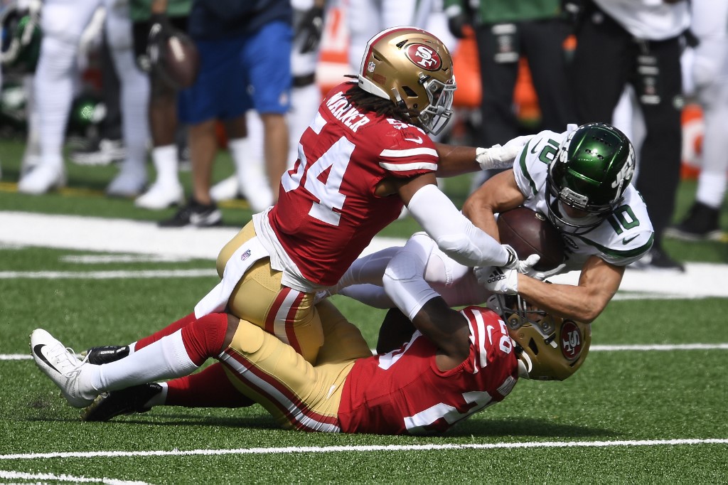 Braxton Berrios of the New York Jets is tackled by Fred Warner and Jimmie Ward of the San Francisco 49ers
