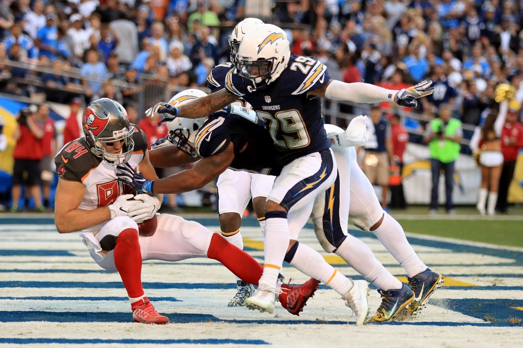 Craig Mager and Jatavis Brown of the Chargers tackle Cameron Brate of the Buccaneers.-NFL Week 4 Betting Odds