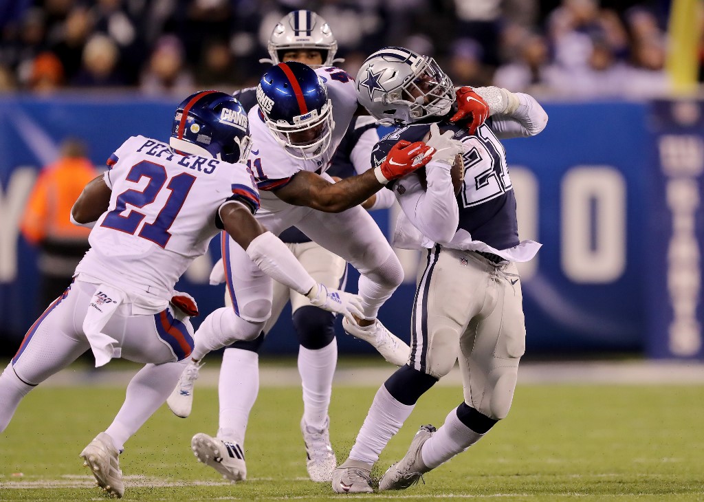 Ezekiel Elliott of the Dallas Cowboys carries the ball as Antoine Bethea and Jabrill Peppers of the New York Giants defend. Giants vs Cowboys Betting Odds