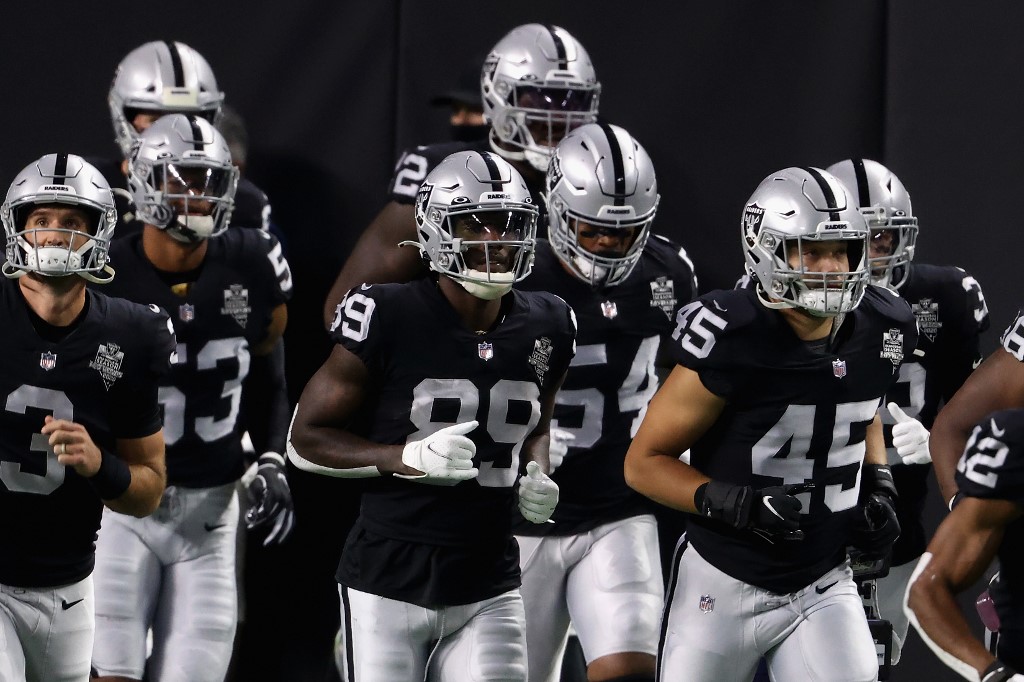 WR Bryan Edwards of the Las Vegas Raiders runs onto the field with teammates during an NFL game. Have a look at our ATS Week 12 Betting Lines