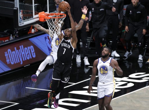 Kevin Durant of the Nets dunks as Kelly Oubre Jr. and Eric Paschall of the Golden State Warriors defend during the first half