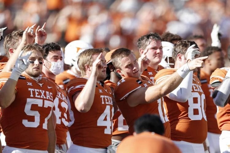 The Texas Longhorns stand for The Eyes of Texas after the game against the West Virginia Mountaineers