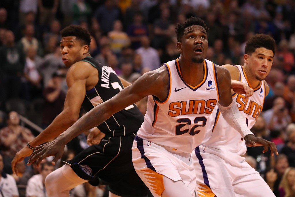 Deandre Ayton & Devin Booker of Phoenix block Giannis Antetokounmpo. Read our Bucks vs Suns betting preview