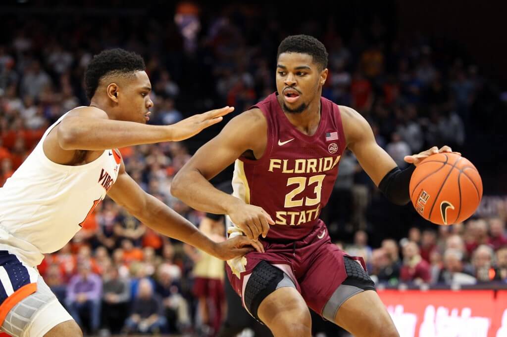 M.J. Walker of the Florida State Seminoles drives toward Casey Morsell of the the Virginia Cavaliers in the first half