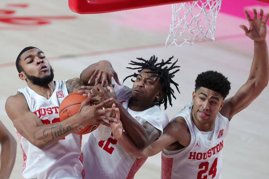 Reggie Chaney, Tramon Mark, and Quentin Grimes of the Houston Cougars fight for a rebound against the Temple Owls