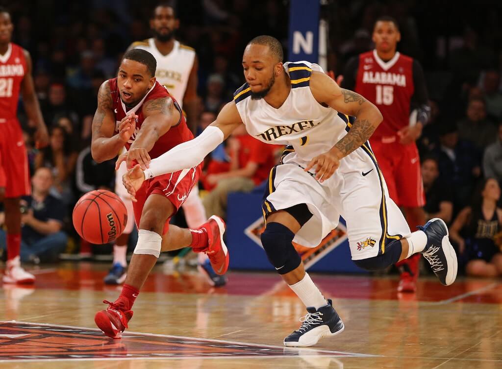 Trevor Releford of the Alabama Crimson Tide and Chris Fouch of the Drexel Dragons battle for the ball