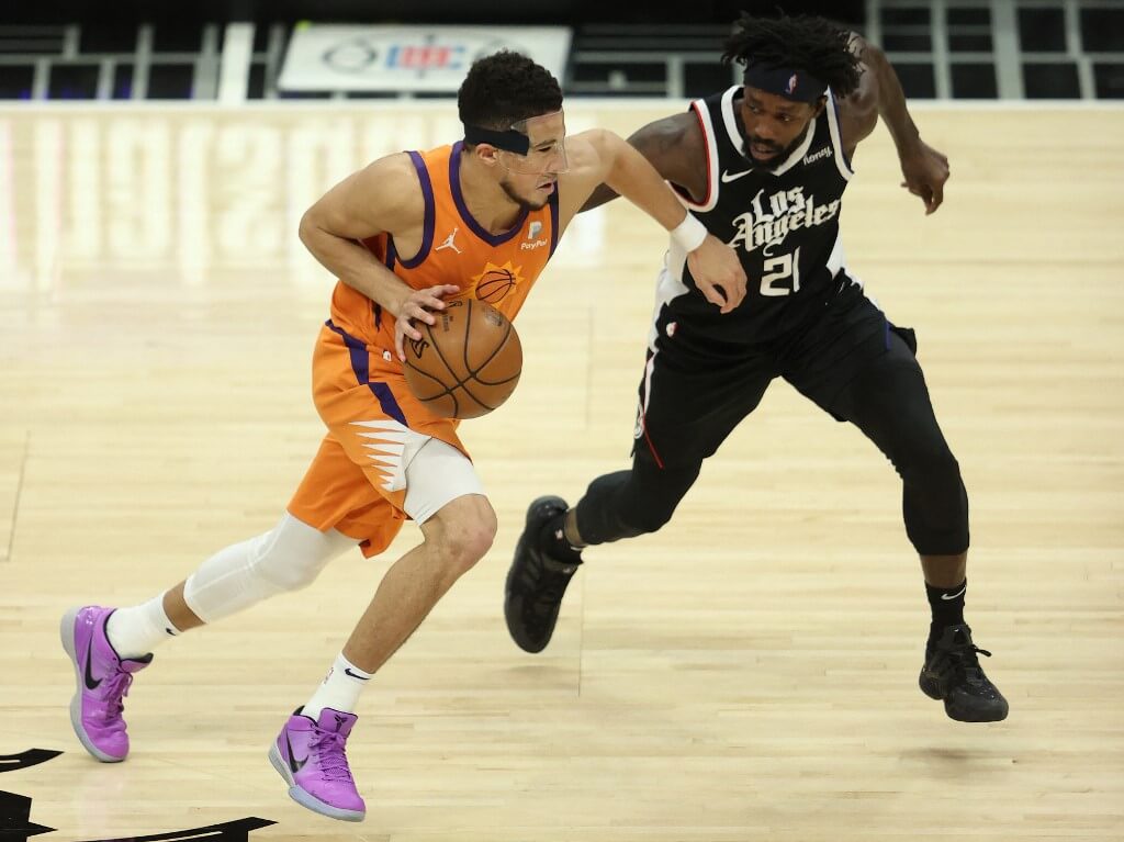 Devin Booker of the Phoenix Suns drives against Patrick Beverley of the LA Clippers