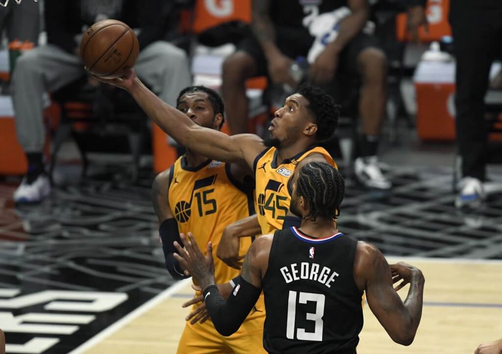Donovan Mitchell of the Utah Jazz scores a basket against Paul George of the Los Angeles Clippers