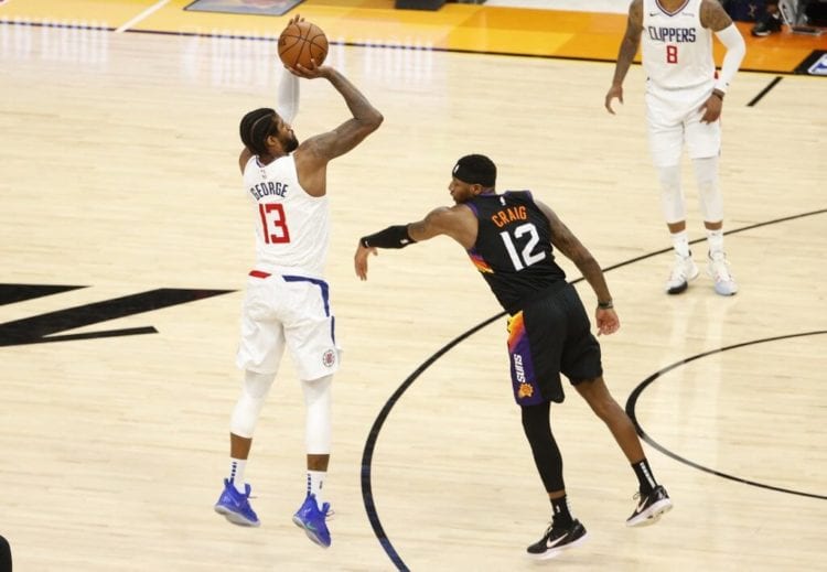 Paul George of the LA Clippers shoots against Torrey Craig of the Phoenix Suns