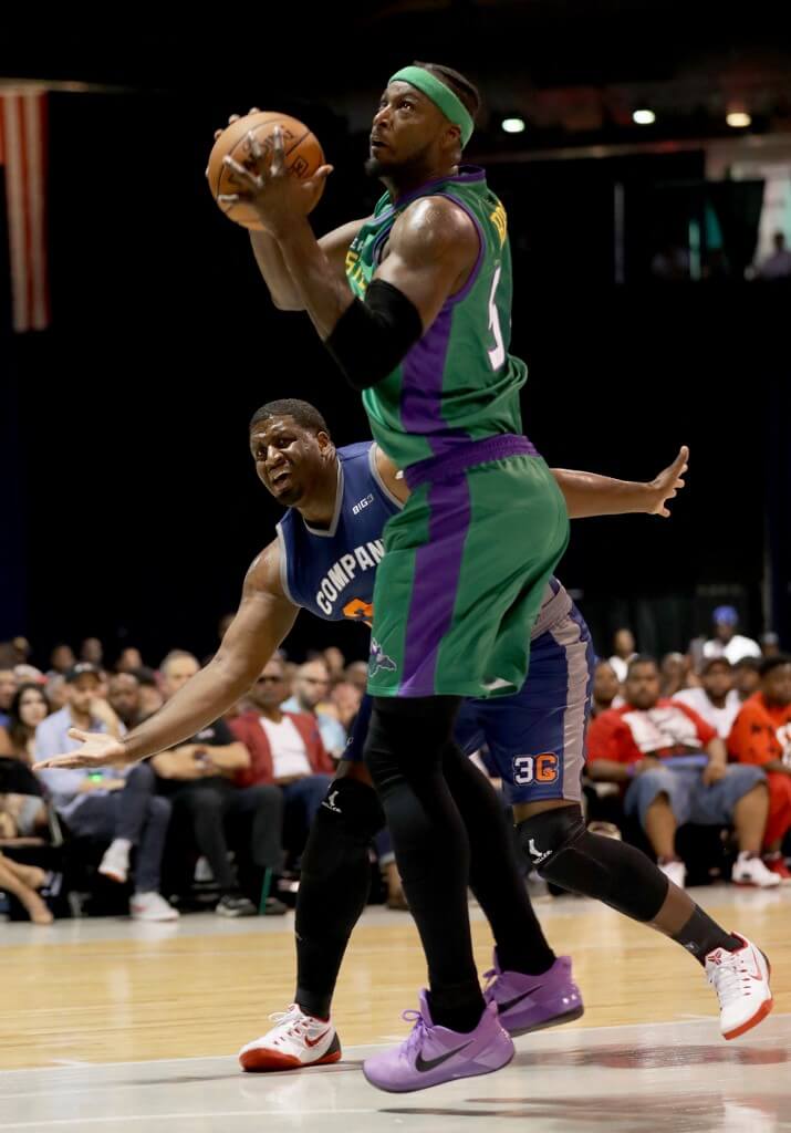 Kwame Brown of the 3 Headed Monsters handles the ball while being guarded by Mike Sweetney