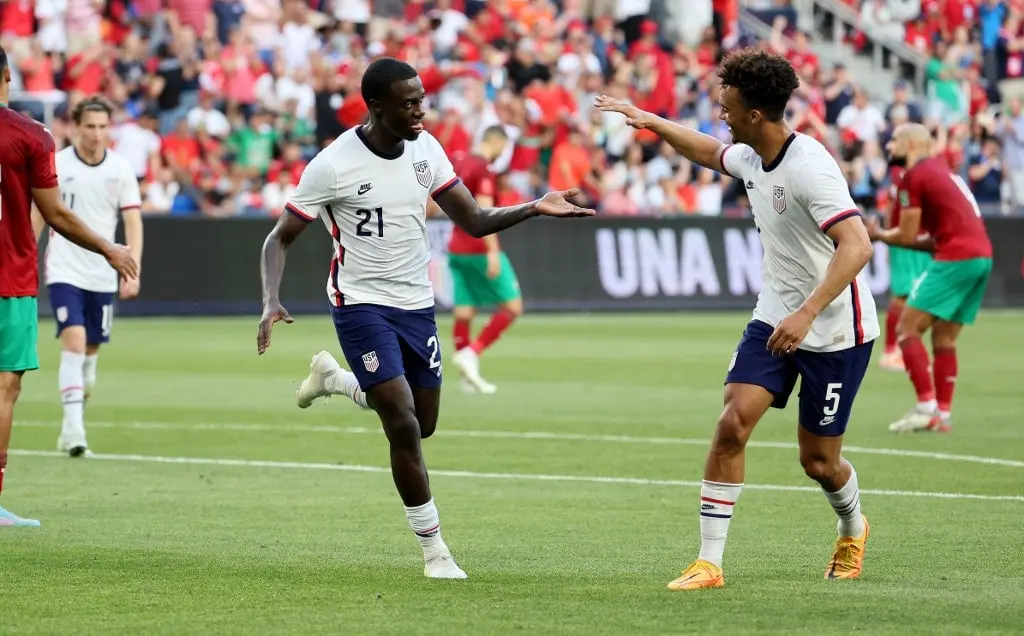 Tim Weah #21of the United States celebrates with Antonee Robinson #5