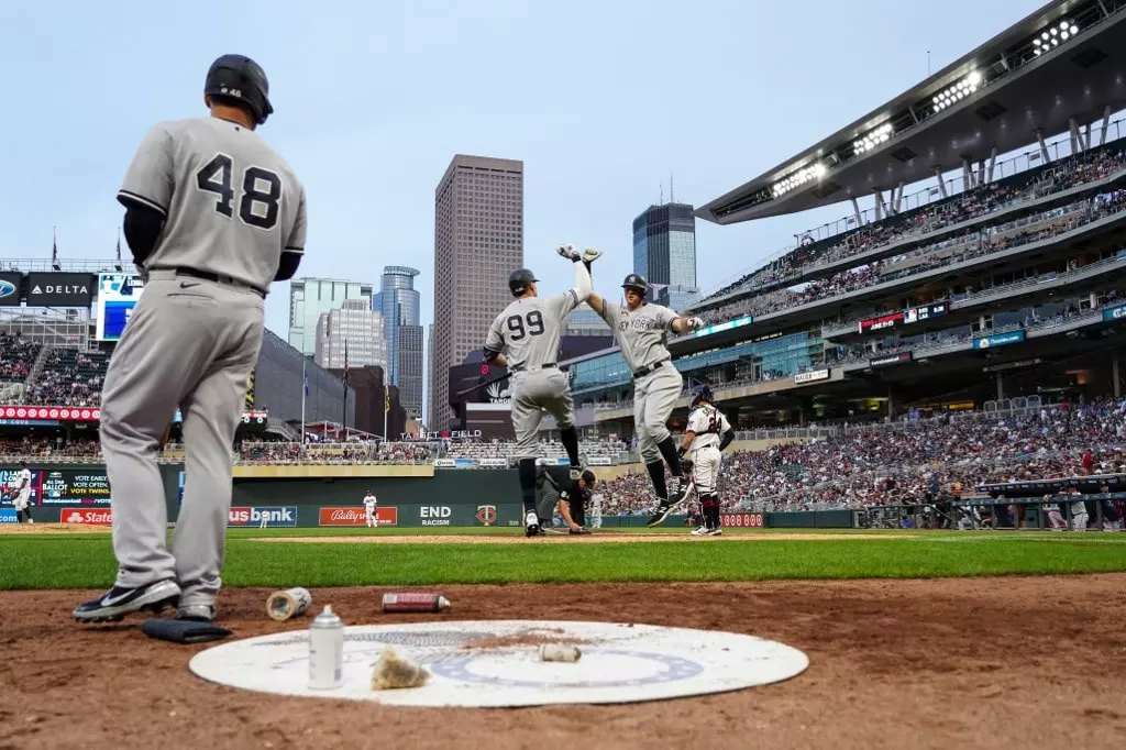 DJ LeMahieu #26 of the New York Yankees celebrates his solo home run with Aaron Judge #99 while Anthony Rizzo #48 looks on in the fifth inning of the game against the Minnesota Twins