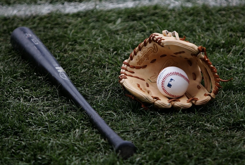 A bat, glove and ball rest on the field before the game.