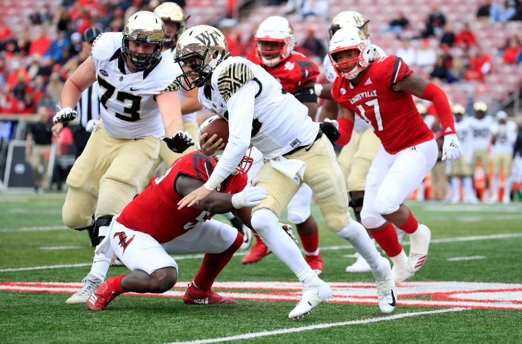 Sam Hartman #10 of the Wake Forest Demon Deacons runs with the ball against the Louisville Cardinals on October 27, 2018