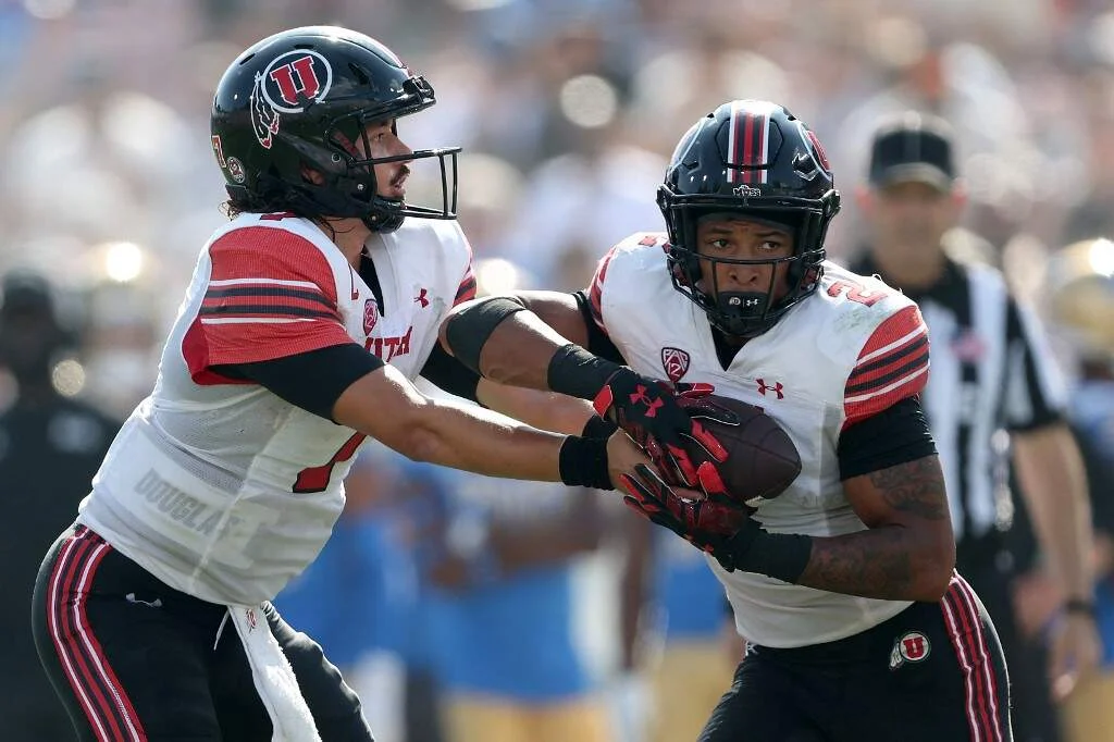 Cameron Rising #7 hands off to Micah Bernard #2 of the Utah Utes