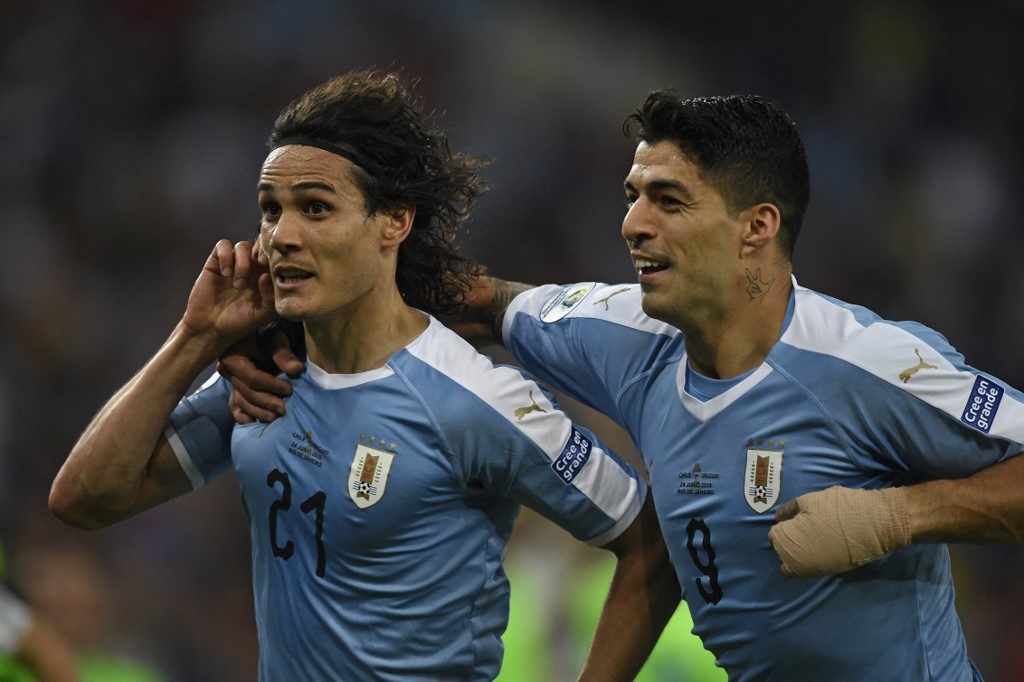 Uruguay's Edinson Cavani (L) celebrates with teammate Luis Suarez after scoring against Chile