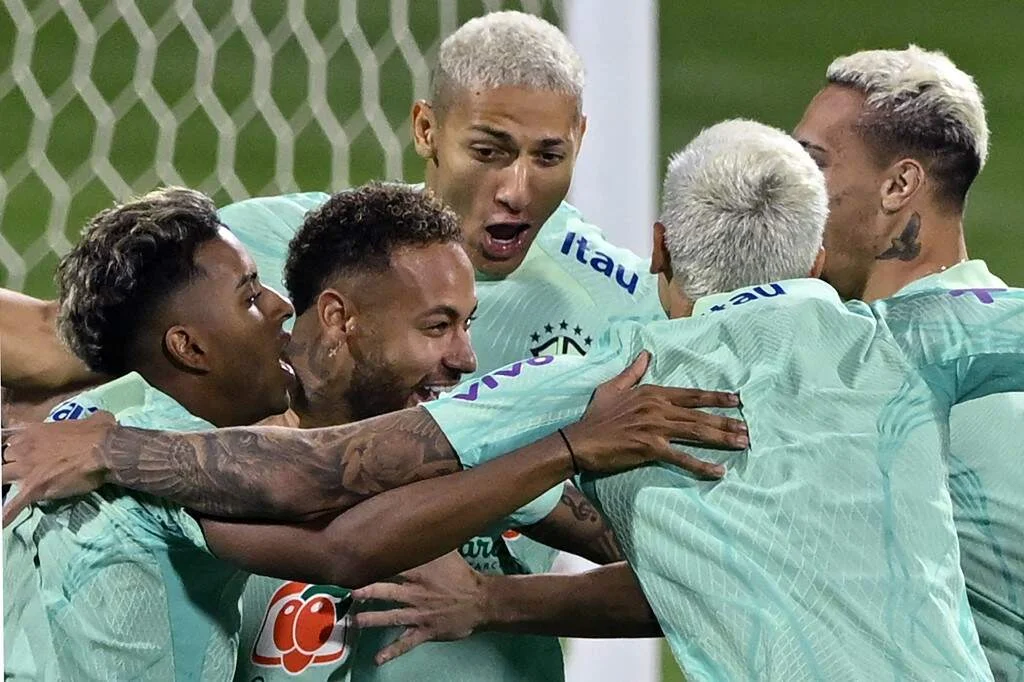 Brazil's forwards Rodrygo (L), Neymar (2-L) and Richarlison (C), celebrate with teammates during a training session