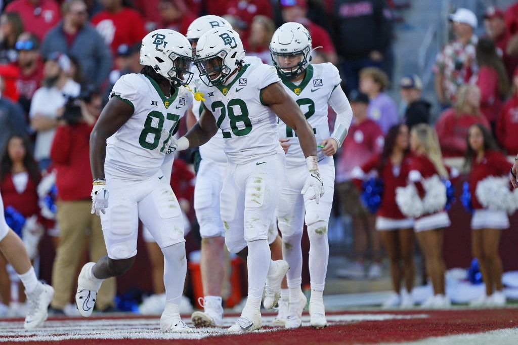 Running back Qualan Jones #28 of the Baylor Bears celebrates his 10-yard touchdown with tight end Kelsey Johnson #87 and quarterback Blake Shapen #12 against the Oklahoma Sooners