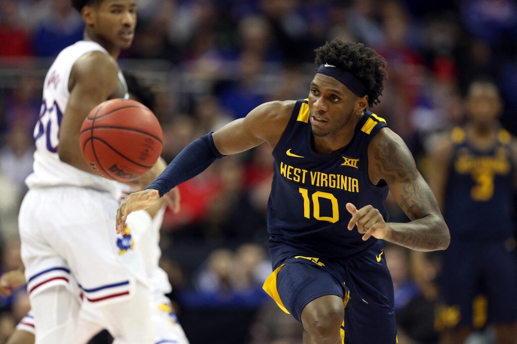 Malik Curry #10 of the West Virginia Mountaineers reaches for a loose ball