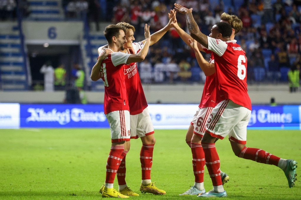 Arsenal's Norwegian midfielder Martin Odegaard (2nd L) celebrates scoring with teammates during the AC Milan and Arsenal friendly match at the Dubai Super Cup 2022