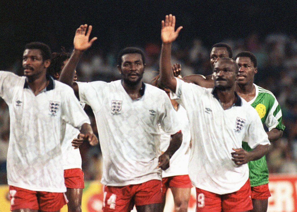 Cameroon's national soccer team players (from L) François Omam Biyick, Stephen Tataw and Roger Milla wave to their fans at the end of the World Cup