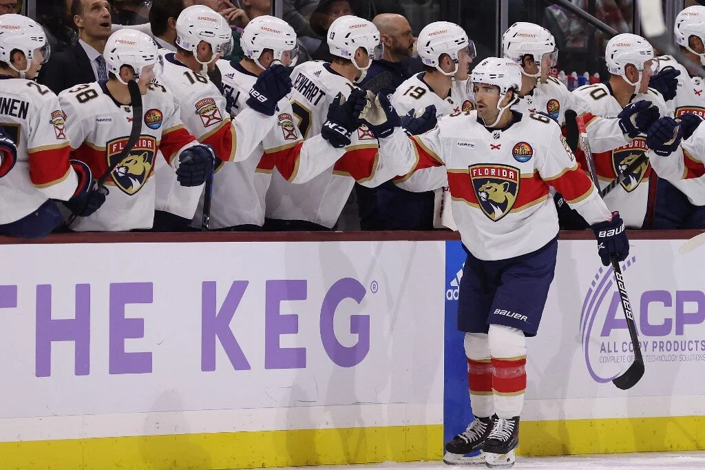 Colin White #6 of the Florida Panthers celebrates with teammates on the bench after scoring a goal