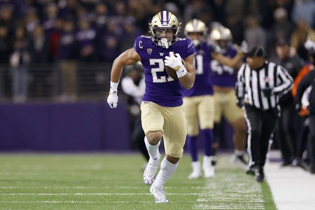 Wayne Taulapapa #21 of the Washington Huskies carries the ball