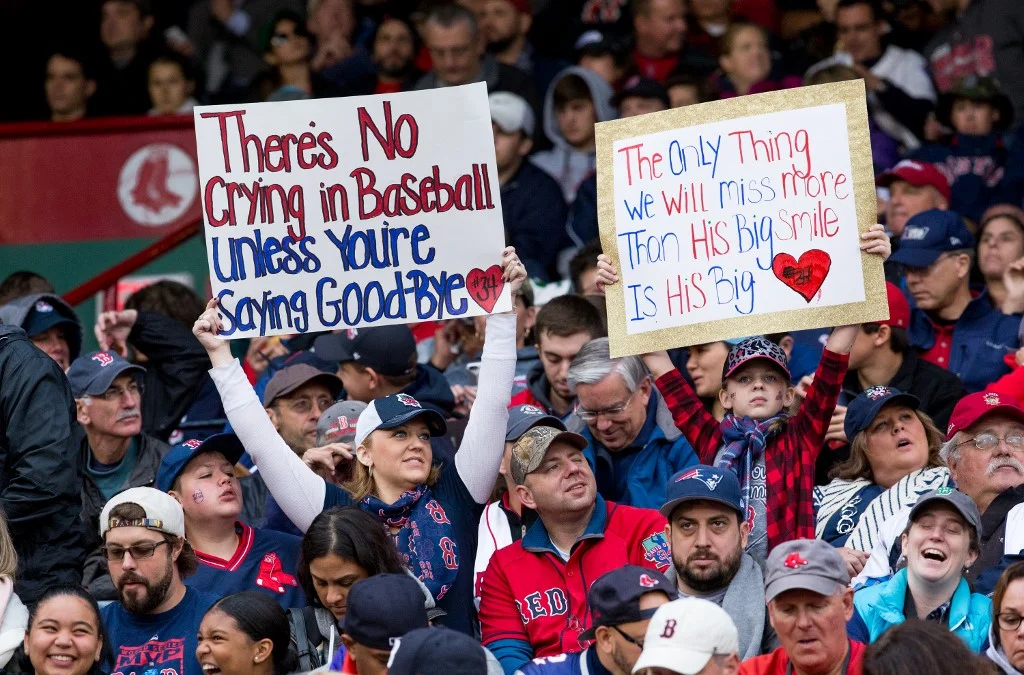 Fans hold up signs during David Ortiz #34 of the Boston Red Sox last regular season game against the Toronto Blue Jays
