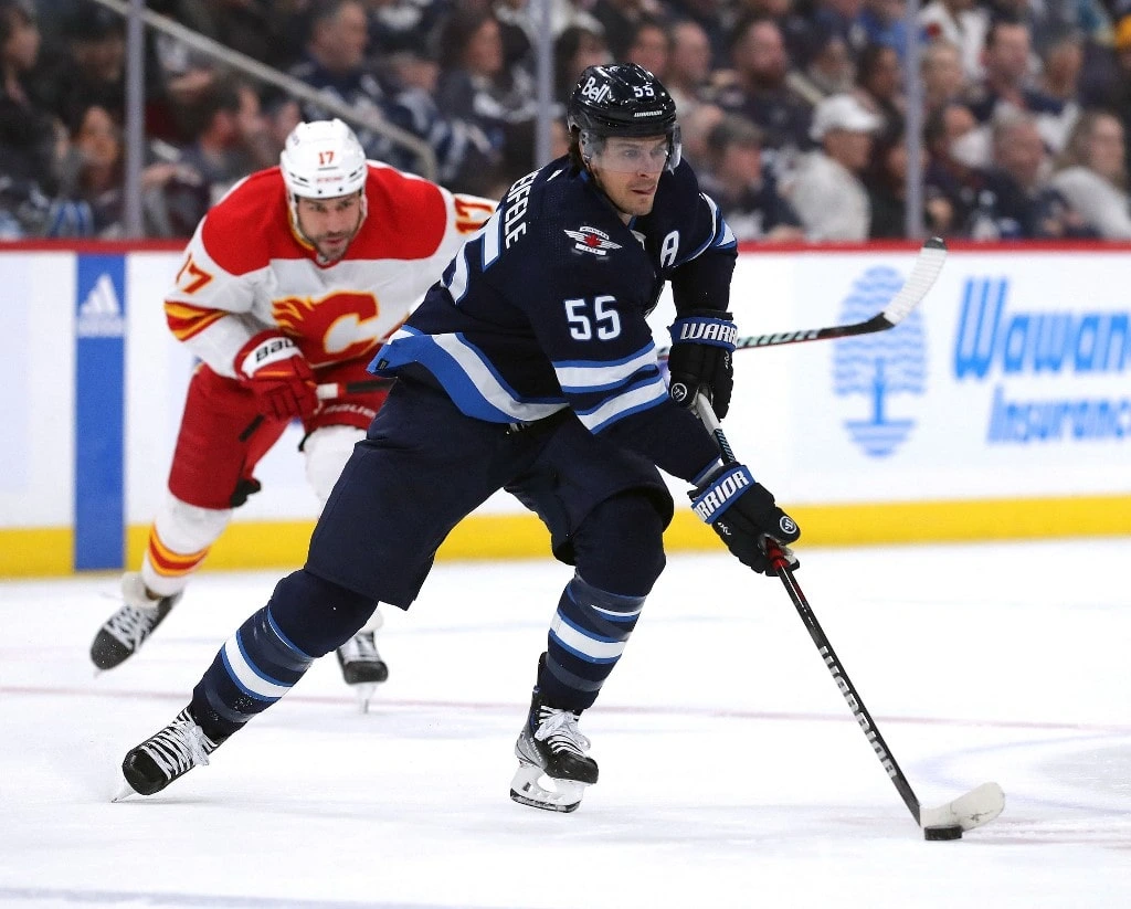 Mark Scheifele #55 of the Winnipeg Jets moves the puck past Milan Lucic #17 of the Calgary Flames - Jason Halstead/AFP